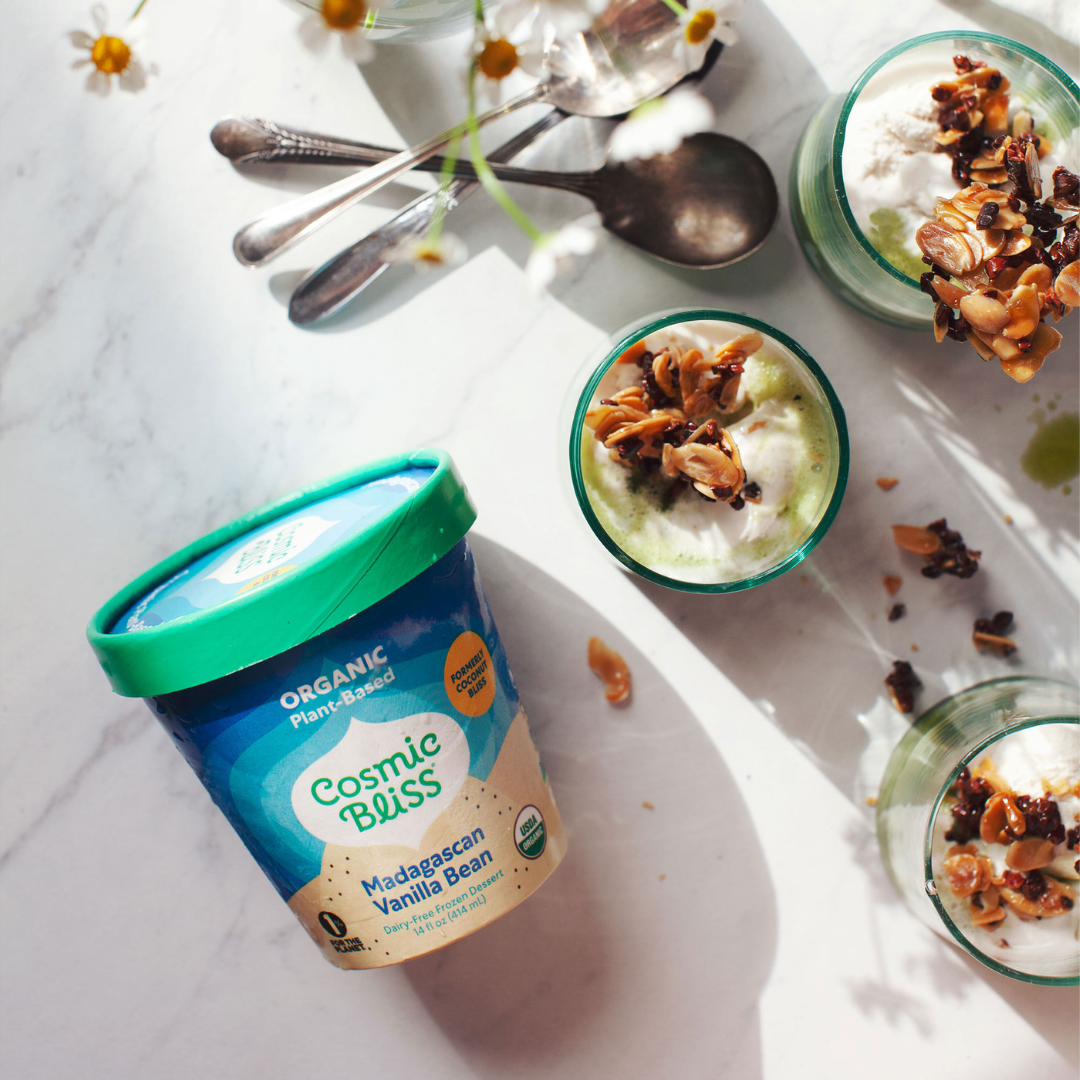 Pint of Cosmic Bliss plant-based Madagascan Vanilla Bean frozen dessert next to 3 cups filled with delicious matcha affogato topped with almond-nib crunchies with a bouquet of flowers above.